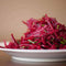 Grated and spiced beetroot slices on a white plate, perfect for adding to a beetroot salad.