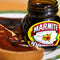 Marmite Yeast Extract 250g jar next to toast with spread.